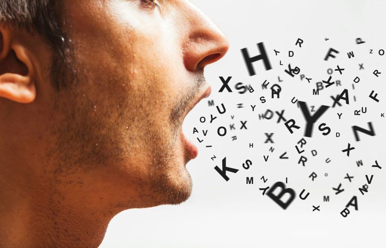 A man speaking, with letters coming out of his mouth.